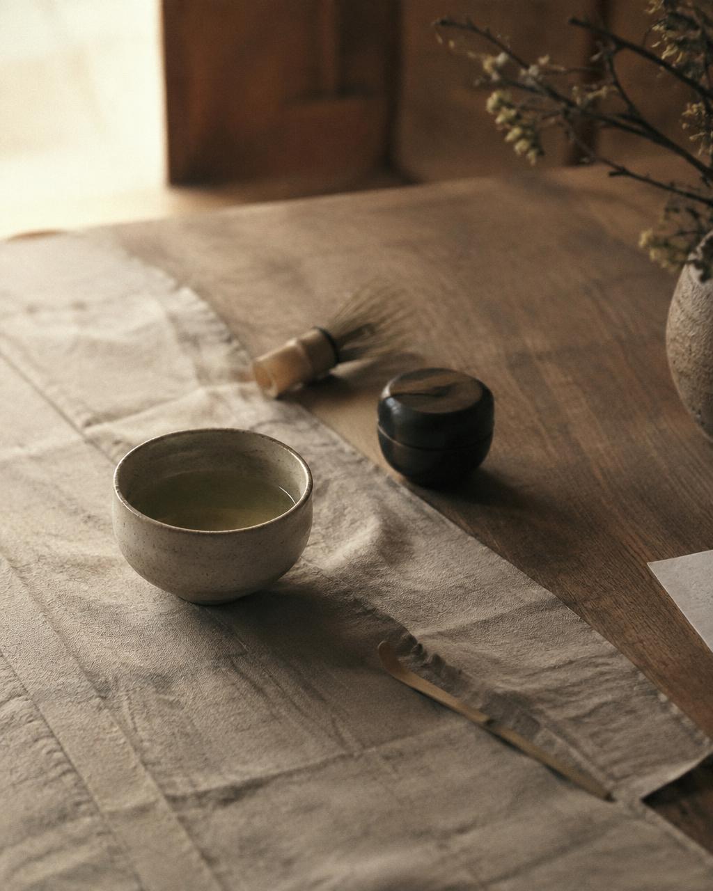 A tea ritual with a stoneware bowl on linen